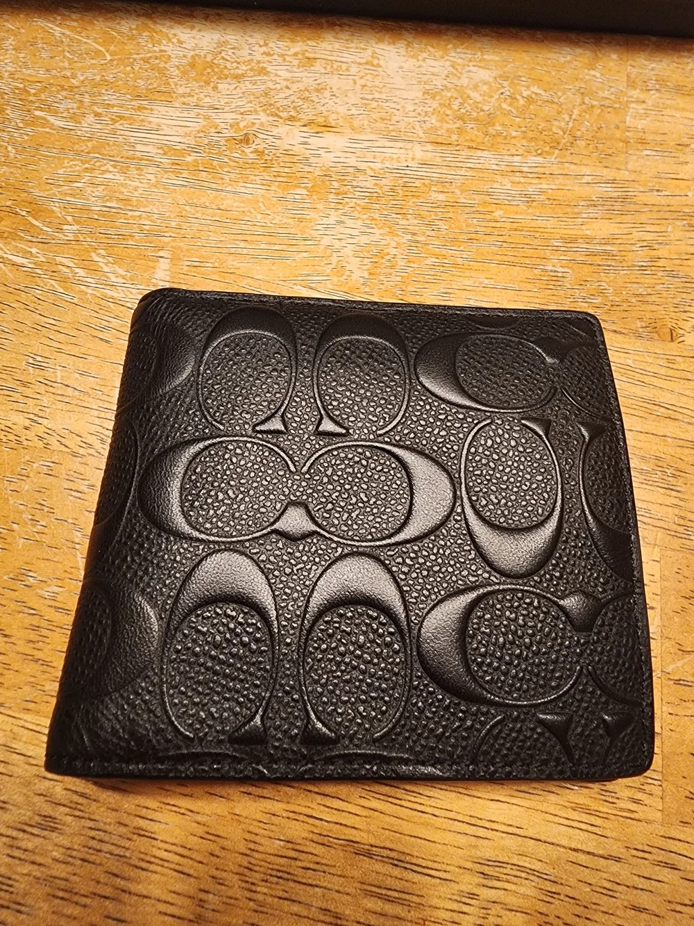 black Coach 3-in-1 wallet featuring the brand's iconic debossed signature pebble